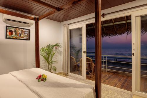 阿贡达Agonda Cottages的一间卧室配有一张床,享有海景