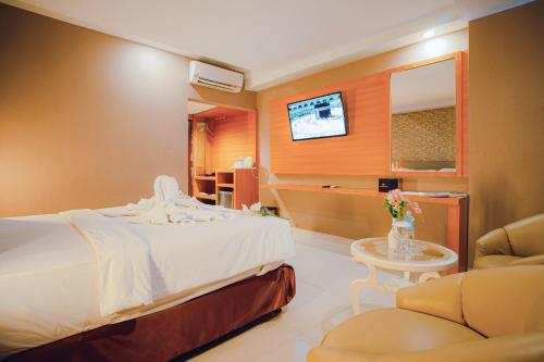 班达亚齐Portola Arabia Hotel Banda Aceh的一间酒店客房,配有一张床和一台电视