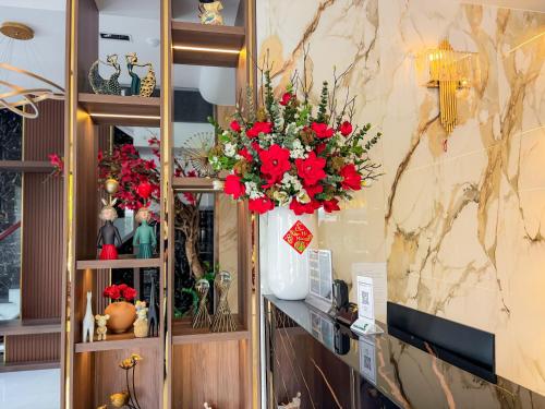 Cao LãnhKHÁCH SẠN THƯ LÊ LUXURY的架子上满是红花的花瓶