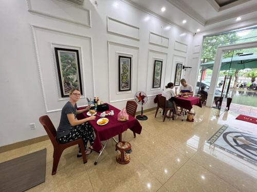 吉婆岛Bao Phuc Hotel的坐在餐厅桌子上的女人