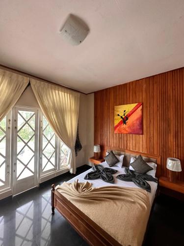 努沃勒埃利耶梅普尔斯旅游度假酒店的一间卧室设有一张大床和一个大窗户