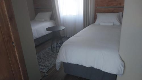 Berea HillsSeqonoka Villa Accommodation & Events Park的一间卧室配有一张床、一张桌子和一个窗户。