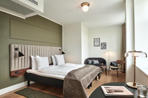 哥本哈根斯卡特托马斯酒店的配有一张床和一张书桌的酒店客房