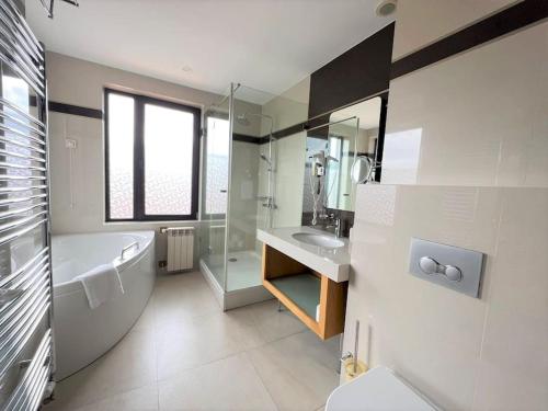 多布里尼什特Villa in Ruskovets Resort的带浴缸、盥洗盆和卫生间的浴室