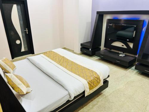 斋浦尔pool loft的一间卧室配有一张床和一台平面电视