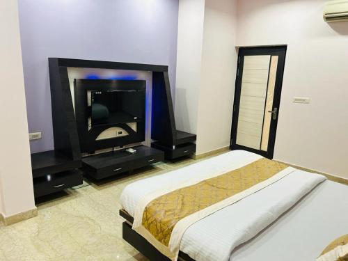 斋浦尔pool loft的一间卧室配有一张床和一台平面电视