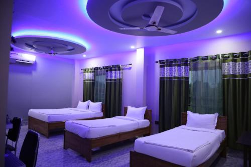 北拉欣布尔HOTEL NAHAR的紫色天花板客房的两张床