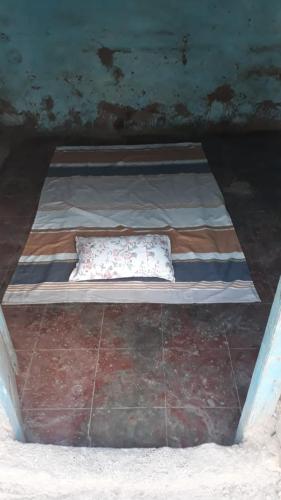 MirajMud House的一张小床,上面有枕头