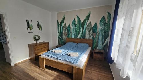 包道乔尼托毛伊Menta Holiday Home的一间卧室配有一张床和一张木叶壁画