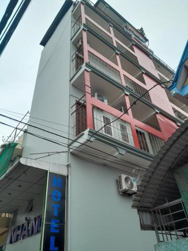 Vu BảnNHÀ NGHỈ TRÀ MY的粉红色和白色的建筑设有阳台