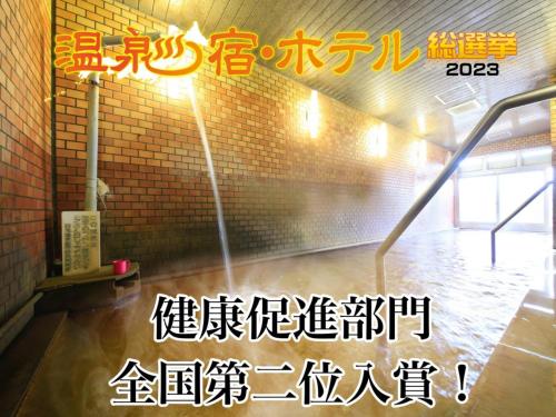 甲斐市吸う温泉 湯治の宿 竜王ラドン温泉 湯ーとぴあ的砖墙中的一个房间,有一个喷泉