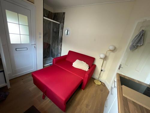 圣伦纳兹Livadia House at St Leonards on Sea的一个带门的房间的红色沙发