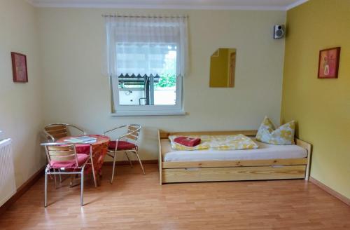 NeusitzFerienwohnung Lindeneck的客房设有床、桌子和窗户。