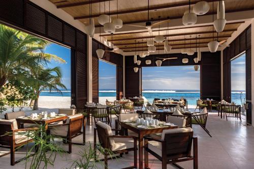 北马累环礁OBLU SELECT Sangeli - Premium All Inclusive with Free Transfers的海滩上的餐厅,配有桌椅