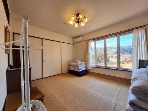 Mimaseguesthouse ONAKA的一间卧室设有一张床和一个大窗户