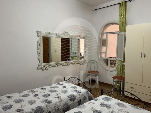 切萨雷奥港Villetta Zora - Spiaggia a 250m的一间卧室配有一张床和镜子