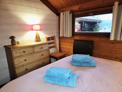莱瓦尔坦Chalet Pura Vida - En pleine nature, tout confort的一间卧室配有一张带2条蓝色毛巾的床