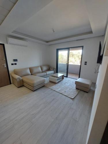 El AhmarThe Wave residence Chott Meriam Sousse的客厅配有沙发和桌子