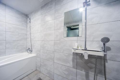 釜山ON:NA Hotel的白色的浴室设有水槽和镜子