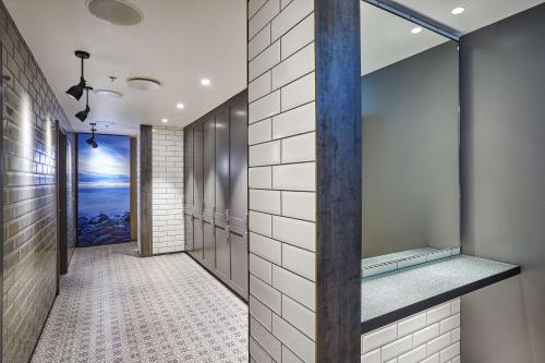 雷克雅未克林冠希尔顿雷克雅未克市中心酒店的浴室铺有白色瓷砖,设有步入式淋浴间。