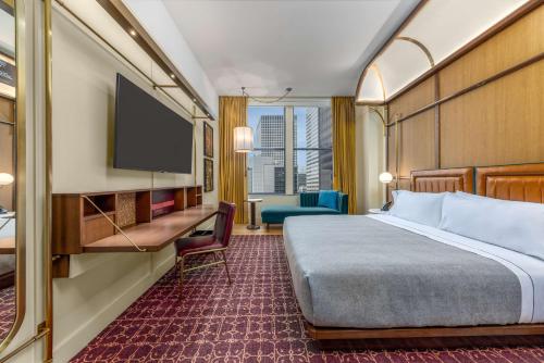 芝加哥Canopy By Hilton Chicago Central Loop的配有一张床和一台平面电视的酒店客房