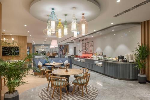 安塔利亚Hampton by Hilton Antalya Airport的一间带桌椅的餐厅以及一间自助餐