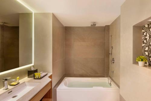 坎多林Hyatt Place Goa Candolim的带浴缸和盥洗盆的浴室