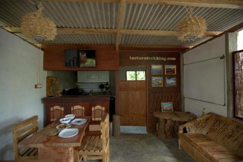 普拉亚Tastura Homestay的配有桌椅和厨房的房间