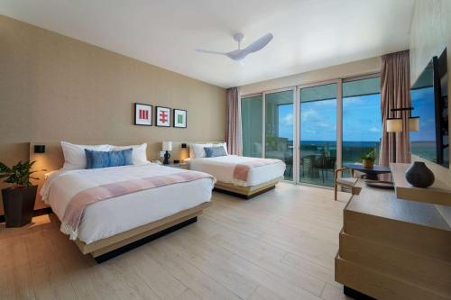 圣菲利普Wyndham Grand Barbados Sam Lords Castle All Inclusive Resort的酒店客房设有两张床和大窗户。