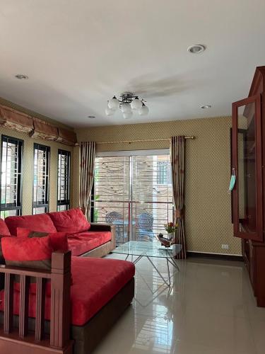 Ban Laem Hinพนาสนธิ์แหลมหินรีสอร์ท的客厅配有红色的沙发和玻璃桌