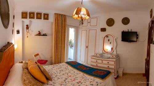 马拉加La Casa de La Abuela Rosy的一间卧室配有一张床、梳妆台和镜子