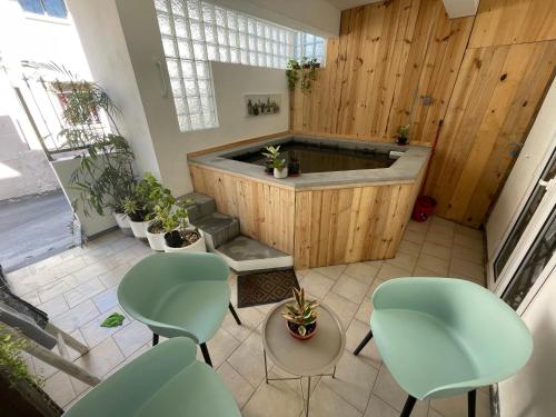 格兰贝伊Sam & Chlo Studio & Appartment - Grand Baie - Mauritius的一个带绿色椅子的房间的热水浴缸