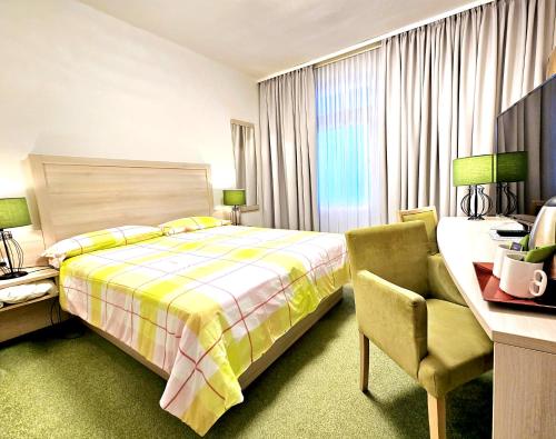 策勒Schifferkrug Hotel & Weinstube的一间卧室配有一张床、一张桌子和一把椅子