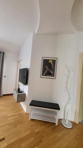米兰San Siro Terrace Attic Apartment Milano的一间带长凳和电视的客厅