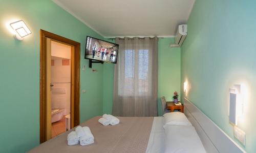 维亚雷焦Hotel Villa Benvenuti的一间卧室设有两张床,墙上配有电视。