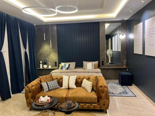 Al ‘Azīzīyahاستديو Studio Hometel VIP的一间卧室配有一张大棕色的沙发和一张床