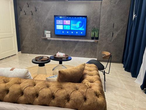 Al ‘Azīzīyahاستديو Studio Hometel VIP的带沙发和平面电视的客厅