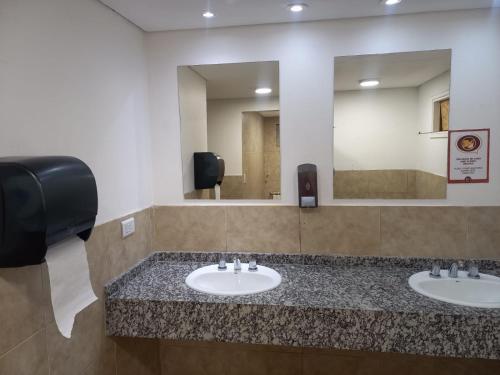 厄尔查尔坦Rancho Aparte Hostel的一间带两个盥洗盆和大镜子的浴室