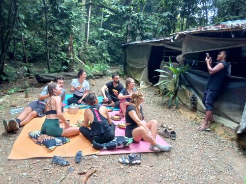 武吉拉旺Jungle treking & Jungle Tour booking with us的一群人坐在帐篷前的毯子上
