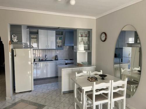 尼亚·蒙达尼亚Baku Apartments的厨房配有白色橱柜和桌椅