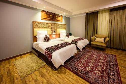 塔伊夫فندق زمان هوم لاند Zaman Homeland Hotel的酒店客房,配有两张床和椅子