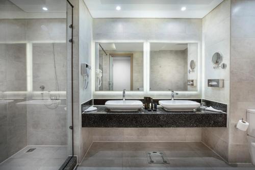 赫尔格达The V Luxury Resort Sahl Hasheesh的一间带两个盥洗盆和淋浴的浴室