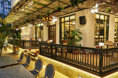 孟买Arnna Hotel- Goregaon East的一间带桌椅的餐厅以及一个阳台