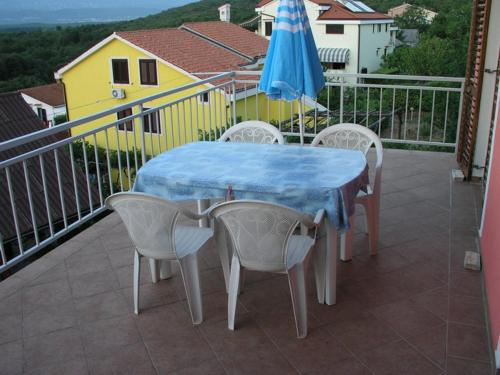 奈维斯Apartmani Bura的阳台配有桌椅和遮阳伞