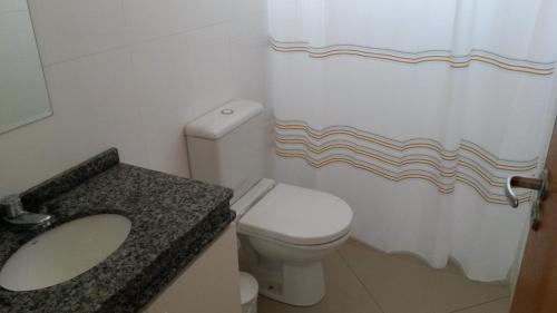 库里提巴Apartamento Central Curitiba的浴室设有卫生间、水槽和淋浴帘