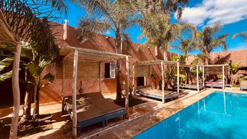 马拉喀什Coco Canel Marrakech的一个带游泳池和棕榈树的度假村