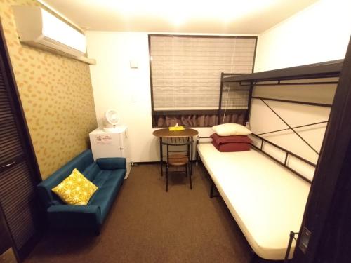 冲绳岛市Guesthome Machiya Koza的小房间设有双层床和桌子