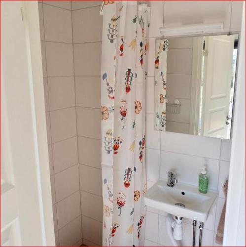 奥胡斯Lunagården的浴室设有水槽和鲜花淋浴帘