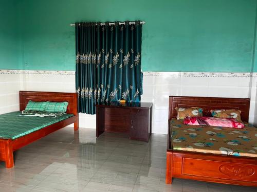 BiđongPhú Cường Tà Đùng Farmstay的一间卧室设有两张床和绿帘