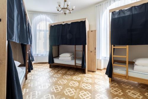 利沃夫索博尼旅舍的一间卧室设有两张双层床和吊灯。